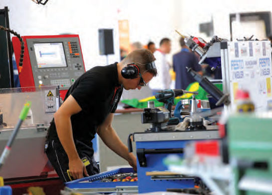 Tineri lucrând la echipamente CNC în cadrul competiției WorldSkills Romania